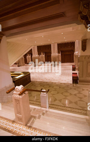 Lobby und Treppe mit hohen Bögen und eine reich verzierte Holzdecke im Royal Opera House in Shati Al-Qurm, Muscat, Oman Stockfoto