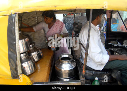 Eine Frau Füllung Trinkwasser in Edelstahl-Behältern in einer Rikscha in einem Slum in Chembur; Bombay-Mumbai Stockfoto