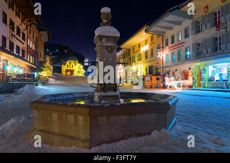 Weihnachtsbeleuchtung in den verschneiten Straßen der mittelalterlichen Stadt Gruyères, Bezirk Gruyère, Kanton Freiburg, Schweiz Stockfoto