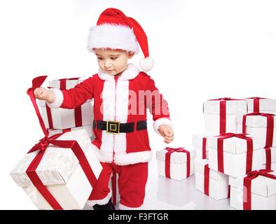 Baby Boy in Santa Claus Kostüm Geschenkbox zu öffnen Stockfoto