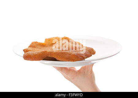 Weibliche Hand Halteplatte mit Wiener Schnitzel isoliert auf weißem Hintergrund mit Reflexion. Traditionelle europäische Küche. Stockfoto