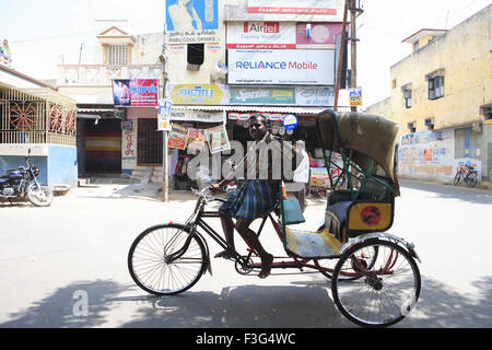 Dreirad-Rikscha und Fahrer auf der Straße; Distrikt Kanchipuram; Tamil Nadu; Indien Stockfoto