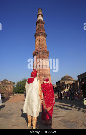 Amerikanische Hochzeitspaar in indisches Kostüm vor Qutb Minar roten Sandstein Turm Indo maurischer Kunst Delhi Stockfoto