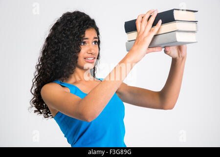 Porträt einer traurigen jungen Frau blickt auf viele Bücher auf einem weißen Hintergrund isoliert Stockfoto