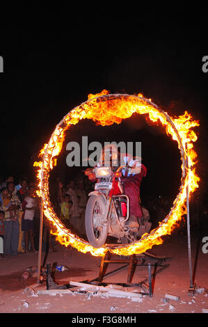 Mann mit Fahrrad durch Feuerring springen; Jodhpur; Rajasthan; Indien Stockfoto