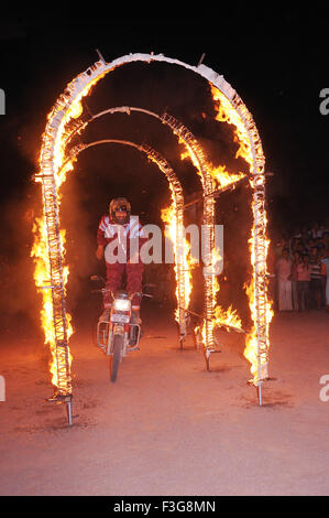 Mann auf Motorrad fahren durch Feuer Bogen; Jodhpur; Rajasthan; Indien Stockfoto