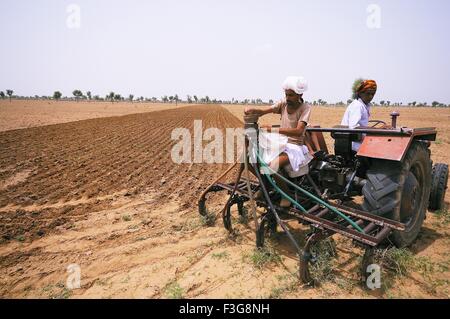 Die Bauern Pflügen Feld mit Traktor; Jajiwal; Jodhpur; Rajasthan; Indien Stockfoto