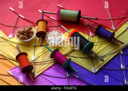 Drachen; eine Spule von bunten Manja; Sesam Chikki Ladoos und Sugardrops für die Feier Makara Sankranti Festival Mumbai Stockfoto