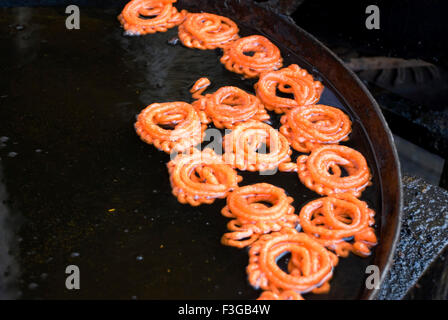 Jalebi in Öl Topf machen Süßigkeiten in Udaipur; Rajasthan; Indien Stockfoto