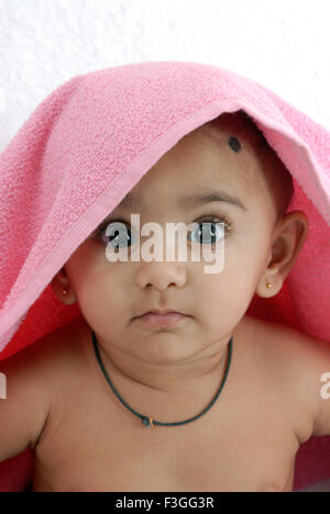 Baby Boy Amulett um den Hals und Kopf mit rosa Handtuch an Kamera HERR Nr. 152 Suche abgedeckt Stockfoto
