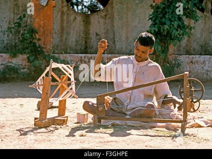 Ein kleiner Junge Spinnen Baumwollgarn an einem Institut basierend auf Gandhi Gedanken Spinnen Weben Ihre eigene Kleidung Gujarat Stockfoto