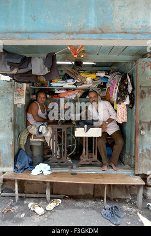 Ein Raum buchstäblich fit genug, um zwei Nähmaschinen und Hocker wird beschäftigt Schneiderei; Mumbai Bombay; Maharashtra Stockfoto