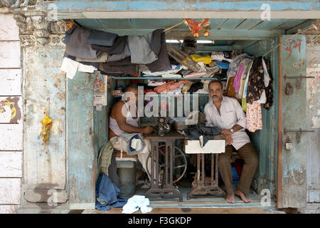 Ein Raum buchstäblich fit genug, um zwei Nähmaschinen und Hocker wird beschäftigt Schneiderei; Mumbai Bombay; Maharashtra Stockfoto