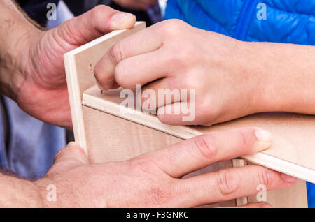 Hand, die einen Nagel eingeschlagen zu werden Stockfoto