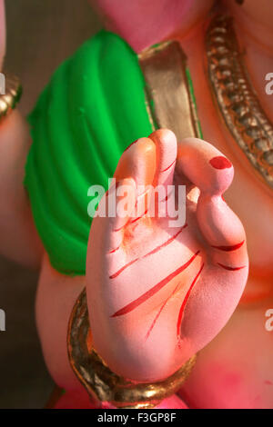 Der bemalte rechten Handfläche gegen einen grün gefärbten Teil der Schulter des Idols von Lord Ganesh; Pune; Maharashtra; Indien Stockfoto