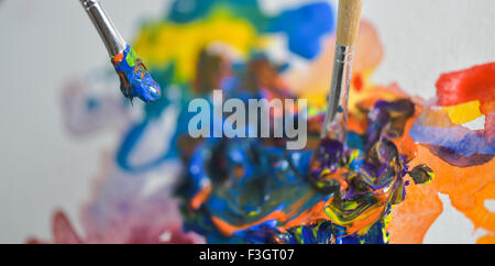 Pinsel Farbe auf der Palette des Künstlers Hand anwenden von Farbe Gouache auf dem Zeichenblatt mischen Stockfoto