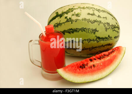 Früchte Wassermelone leichte dunkelgrünen Streifen Glas Melonensaft Scheibe zeigen rote wässrige Fruchtfleisch schwarze Samen Pune Maharashtra schneiden Stockfoto