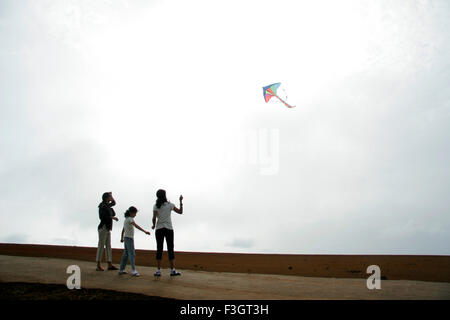 Familie eine bunte Kunststoff Drachen auf Hochebene Panchgani Maharashtra, Indien Stockfoto