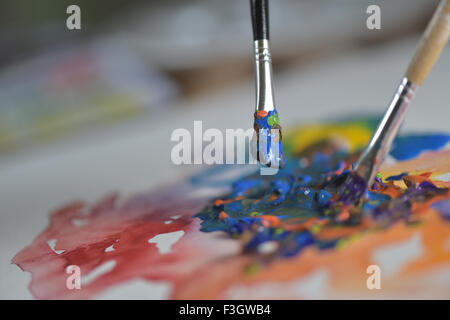 Pinsel Farbe auf der Palette des Künstlers Hand anwenden von Farbe Gouache auf dem Zeichenblatt mischen Stockfoto