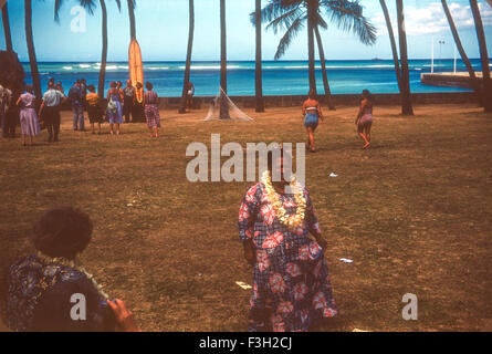 Touristen besuchen eine Luau auf Hawaii in den 1950er Jahren mit Unterhaltung von Hawaiianer. Touristen mit hawaiianischen tragen ein Lei herumstehen Stockfoto