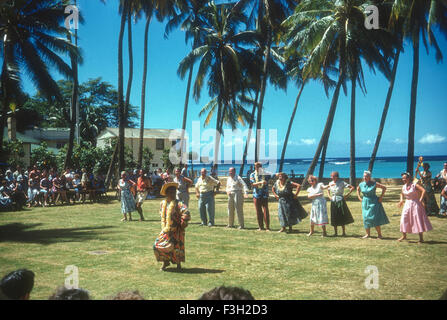 Touristen besuchen eine Luau auf Hawaii in den 1950er Jahren mit Unterhaltung von Hawaiianer. Touristen aus dem Festland tanzen und tragen leis Stockfoto