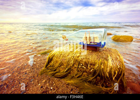 Das Schiff in der Flasche am Strand liegen. Souvenir-Konzeptbild. Natur im Paradies. Stockfoto