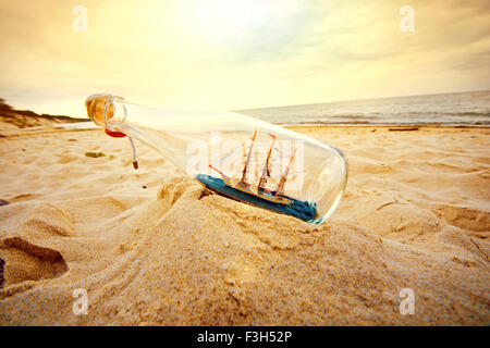 Das Schiff in der Flasche am Strand liegen. Souvenir-Konzeptbild. Natur im Paradies. Stockfoto