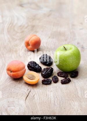 Grüner Apfel, Aprikosen und Pflaumen auf Holztisch Stockfoto