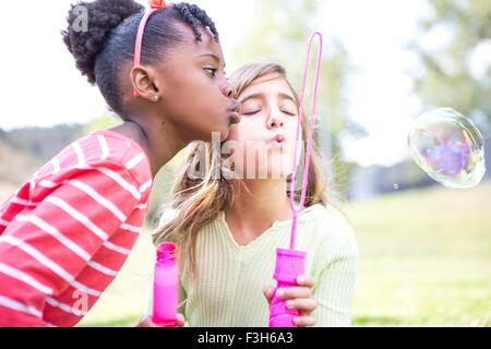 Mädchen bläst Seifenblasen im park Stockfoto