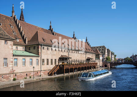 Ausflugsschiff mit Touristen vor mittelalterlichen Old Custom House / Ancienne Douane entlang Fluss Ill in Straßburg, Frankreich Stockfoto