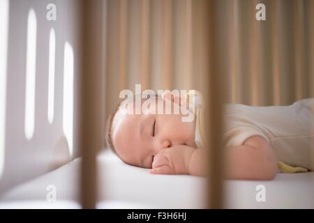 Babyjungen schlafen im Kinderbett Stockfoto