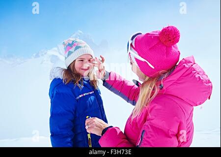 Mutter, die Anwendung von Sonnencreme auf Tochter Gesicht, Chamonix, Frankreich Stockfoto