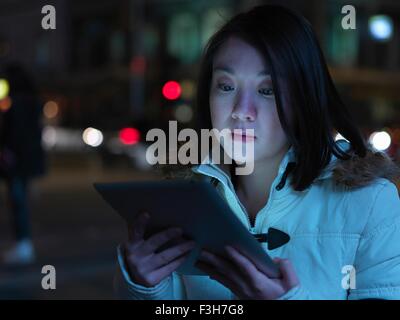 Junge Frau in der Straße, in der Nacht, mit digital-Tablette Stockfoto