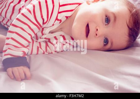 Baby Boy auf Bett liegend Stockfoto