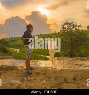 Kleiner Junge Angeln im Bach, mit Angeln net, niedrigen Winkel Ansicht Stockfoto