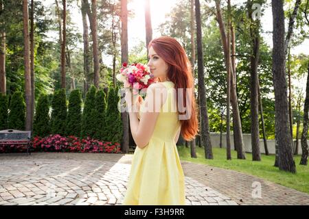 Junge Frau mit Blumen im park Stockfoto