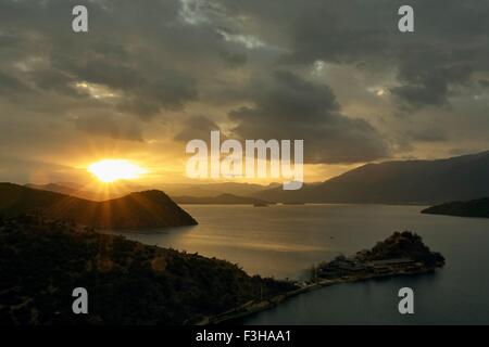 Silhouette Berge und Lugu-See bei Sonnenaufgang, Yunnan, China Stockfoto