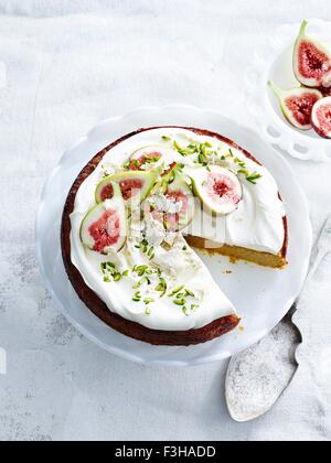 Draufsicht der orange-Mandel-Kuchen mit Joghurt-Creme, Pistazien, Feigen und Tortenheber Stockfoto