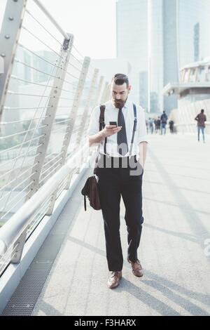 Geschäftsmann lesen Smartphone Text Update beim gehen auf Steg Stockfoto