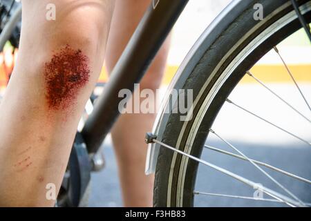 Verkürzten Blick auf Fahrrad und Mädchen Bein mit Weidegras Knie Stockfoto