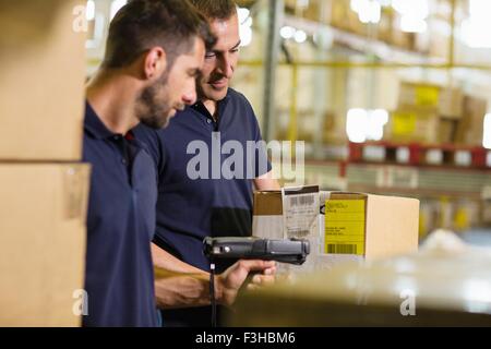 Männliche Lagerarbeiter mit Barcodescanner im Auslieferungslager Stockfoto