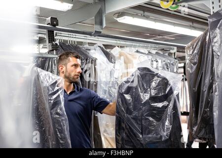 Männliche Lagerarbeiter Kleidungsstück Bestandsaufnahme im Auslieferungslager zu tun Stockfoto