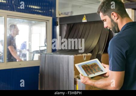 Vorgesetzten Xray mit digital-Tablette in Luftfracht Lager prüfen Stockfoto