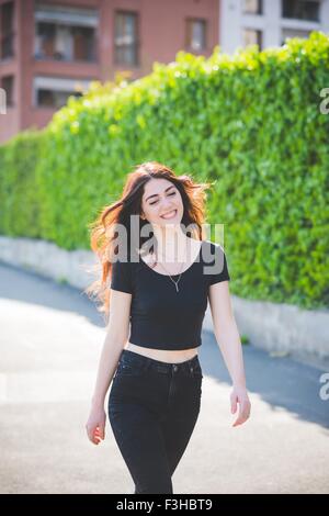 Schöne junge Frau mit langen braunen Haaren, einem Spaziergang