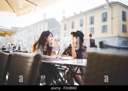 Zwei junge Frauen im Chat im Straßencafé Stockfoto