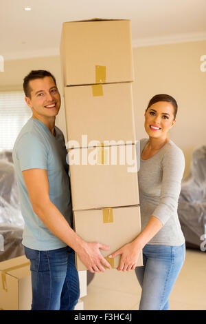 glückliches junges Paar tragen Kartons im neuen Haus Stockfoto