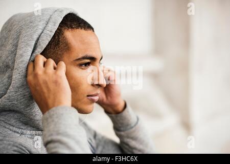 Männliche Läufer tragen Grey hoody setzen in Kopfhörer Stockfoto