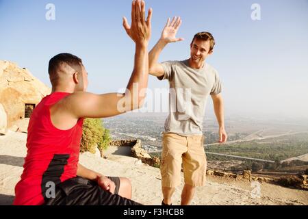 Zwei männliche Freunde, auf Berg, geben hohe fünf Stockfoto