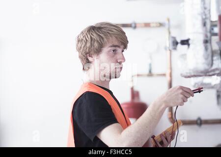 Seitenansicht des jungen Mannes mit hohen visability zeigen Weste Test Heizsystem Stockfoto