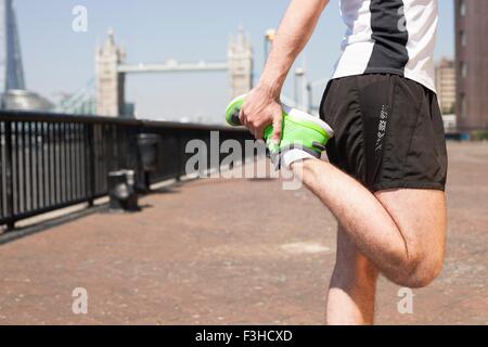 Läufer, die Dehnung am Flussufer, Wapping, London Stockfoto